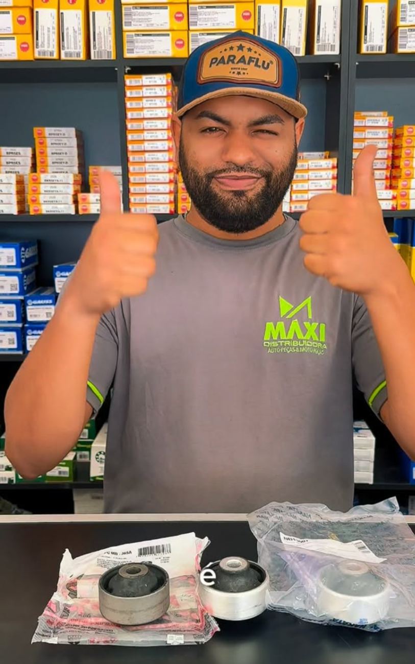 Atendente da Máxi mostrando peças no balcão